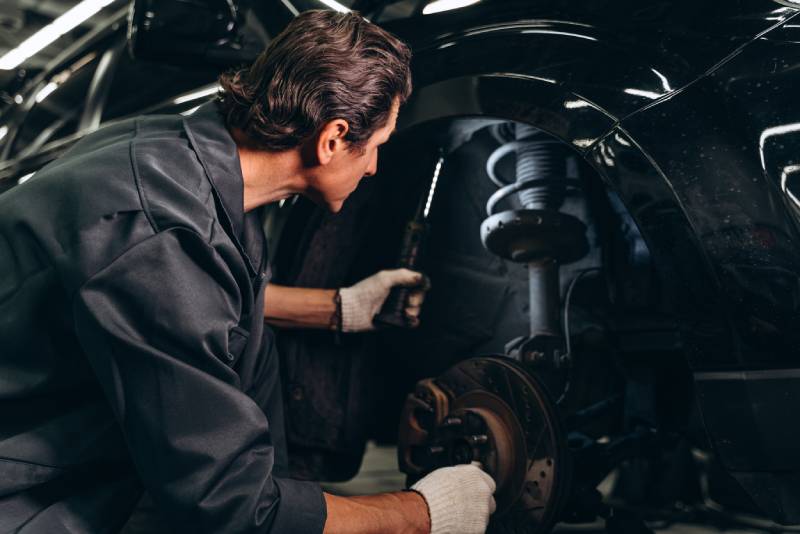 back-view-of-car-mechanic-sitting-near-the-broken-2026-03-10-02-10-04-utc (1)