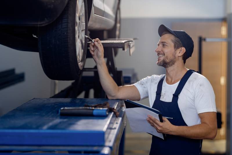 happy-auto-repairman-examining-car-tires-in-a-work-2026-01-06-10-26-42-utc (1)
