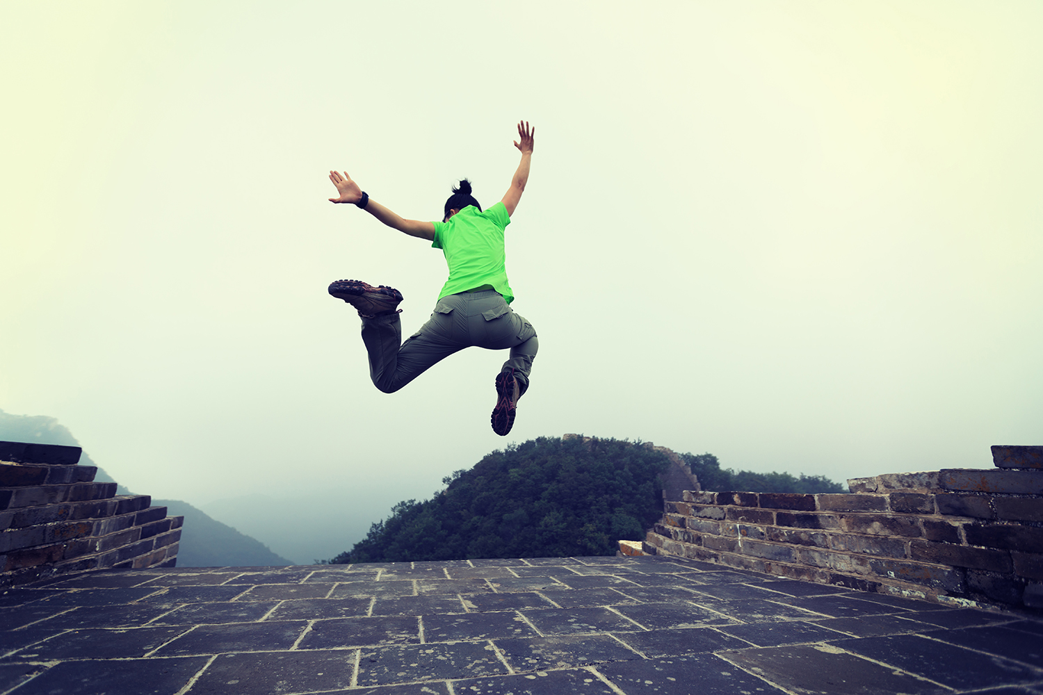 successful woman hiker jumping on great wall